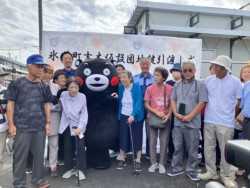 くまモンと笑顔で記念写真を撮影する入居者ら