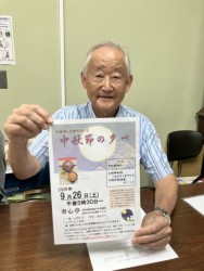 チラシを持ちイベントをアピールする松野会長