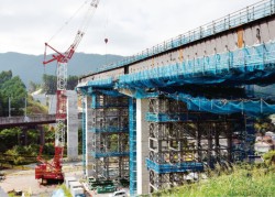 九州新幹線の高架の上をつなぐ古城第二橋（同298m）の上部工工事。30mを超える高さがあり、大型クレーンを用いた橋桁工事が急ピッチで進む